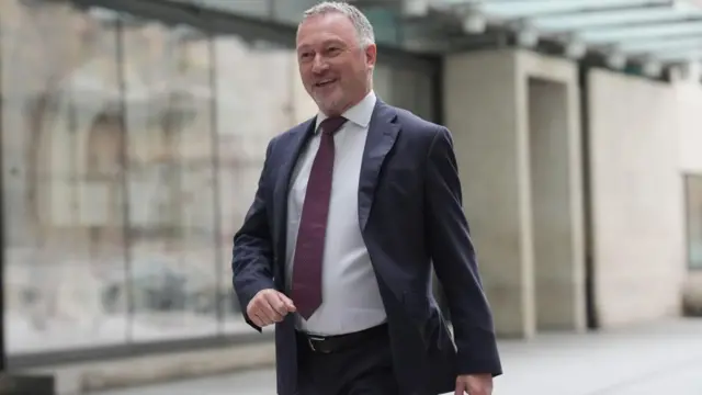 Steve Reed smiles as he walks through the BBC plaza