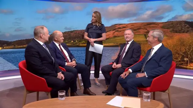 From left to right sitting: Ed Davey, Kevin Hollinrake, Steve Reed and Nigel Farage all wearing suits and sitting on red chairs. Standing in the centre is presenter Laura Kuenssberg
