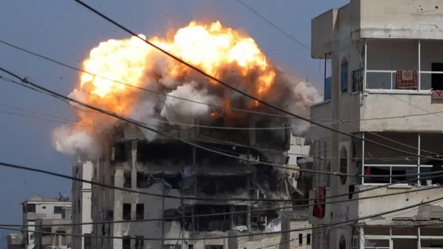 Smoke and flames rise from a residential building hit by an Israeli strike, in Gaza City July 21, 2025