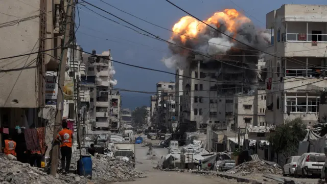Smoke and flames rise from a residential building hit by an Israeli strike, in Gaza City