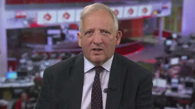 Sir Jon Cunliffe in a suit in a BBC Newsroom