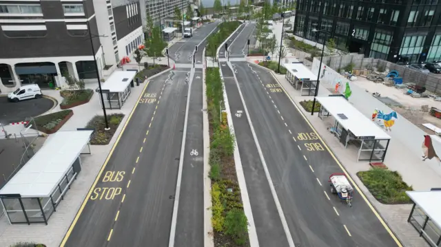 Freshly painted roads lined with bus stops, newly planted shrubbery, new markings for bus stops and cycle paths.