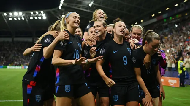 Chloe Kelly of England celebrates with her teammates after scoring her team's second goal from a rebound following a saved penalty in extra-time