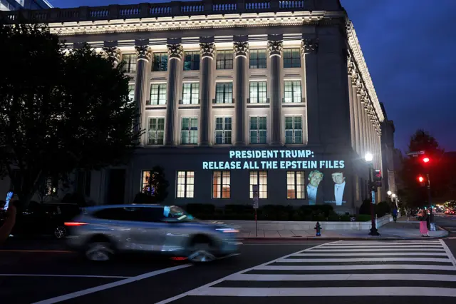An image of U.S. President Donald Trump and Jeffrey Epstein, along with the words “President Trump: Release All the Epstein Files”, is projected onto the U.S. Department of Commerce headquarters.