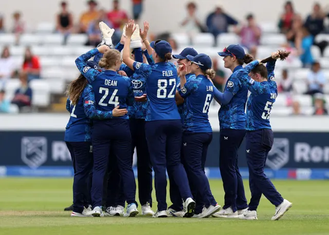 The England team celebrate after taking the wicket of Pratika Rawal