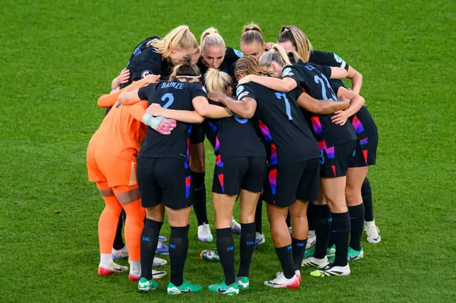 England players gather around in a team huddle