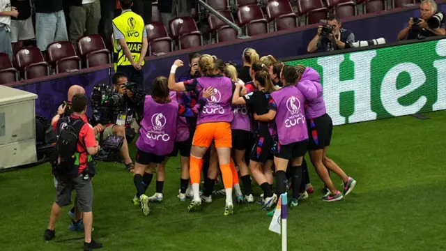 Chloe Kelly of England celebrates with teammates after scoring her team's second goal from a rebound following a saved penalty in extra-time