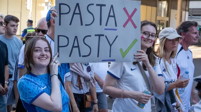 Fans of England hold up a sign