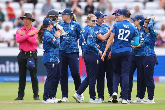 England's Charlie Dean celebrates with teammates after taking the wicket of India's Pratika Rawal
