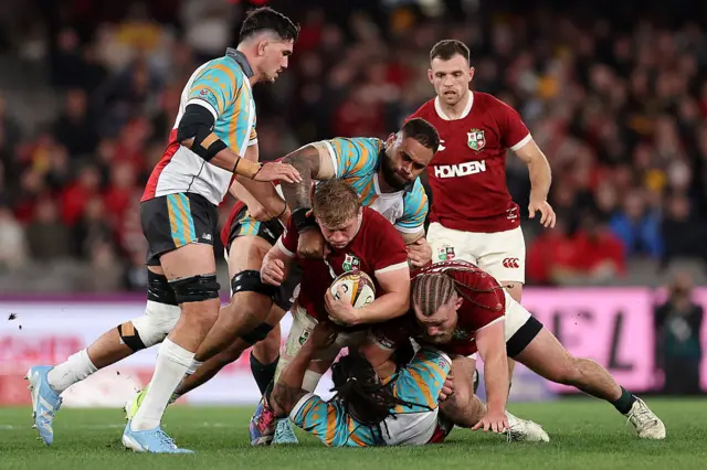 British and Irish Lions' Jac Morgan (C) is tackled