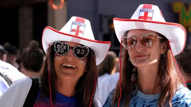 Two female fans wearing customised sunglasses
