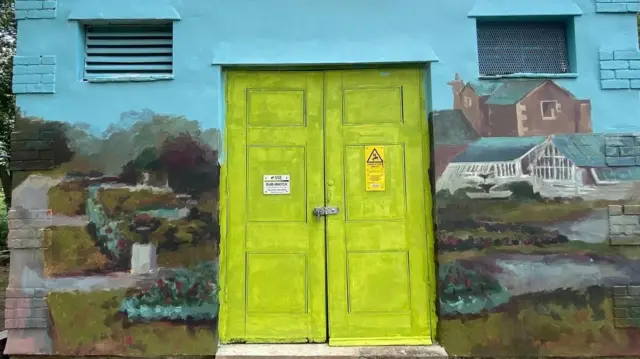 One side of a mural around a bright green doorway