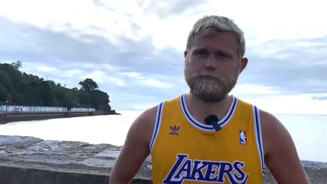 Ben Flowers wearing a yellow basketball shirt.