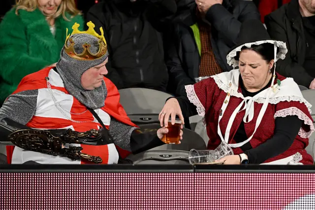 Supporters of the British and Irish Lions dressed in costumes sit in the stands during the tour match