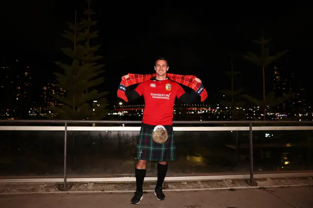 A Lions fan pose for a photo outside the stadium