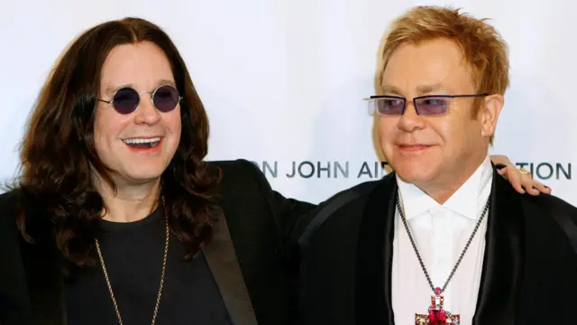 Ozzy Osbourne, smiling, with his arm around singer Elton John.