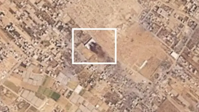 A satellite image shows an area in white, where there is smoke seen rising above it.