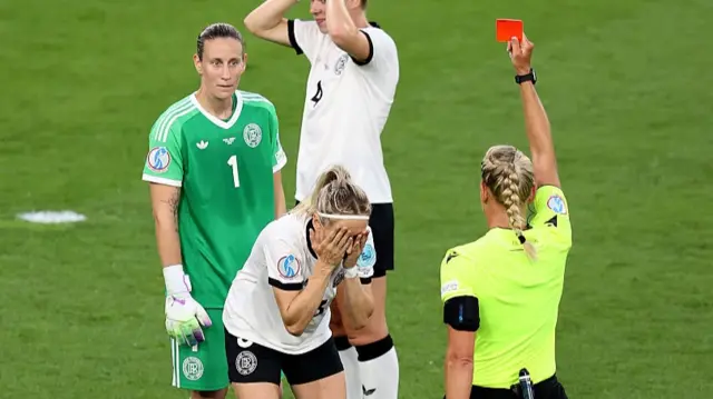 Kathrin Hendrich of Germany looks dejected as she reacts after being shown a red card by Referee Tess Olofsson, after pulling the hair of Griedge Mbock Bathy of France