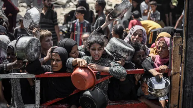People queue for food in Gaza City