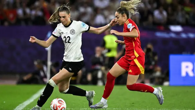 Germany's midfielder #22 Jule Brand (L) and Spain's defender #07 Olga Carmona (R) fight for the ball