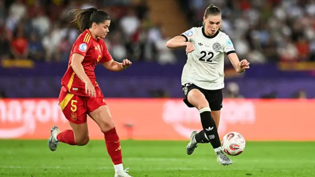 Germany's midfielder #22 Jule Brand (R) runs with the ball in front of Spain's defender #05 Maria Mendez (L)