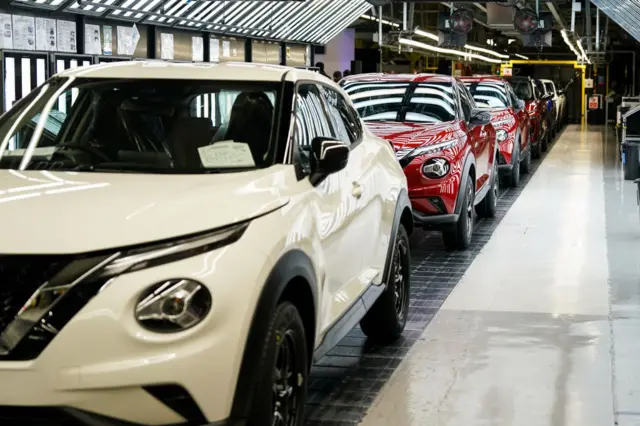 A row of cars on a conveyor belt