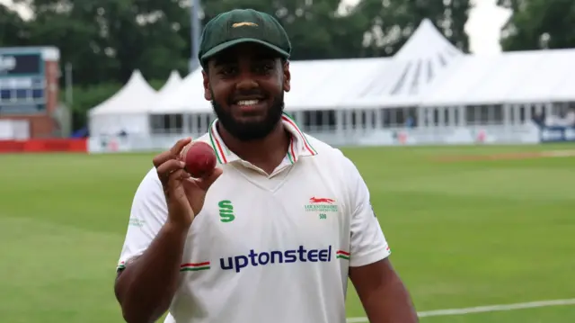 Leicestershire's Rehan Ahmed celebrates with the ball after taking six wickets