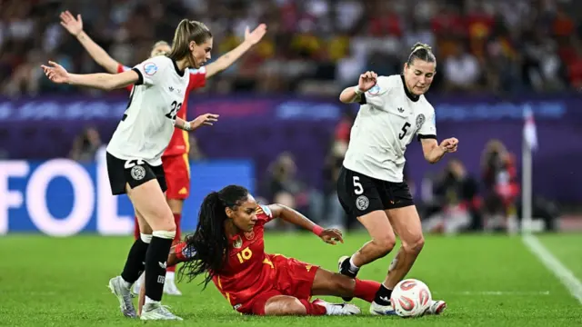 Spain's forward #18 Salma Paralluelo (C) fights for the ball with Germany's forward #05 Carlotta Wamser (R) and Germany's midfielder #22 Jule Brand (L)