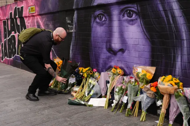 Flowers left at Sabbath mural