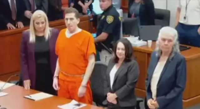 Kohberger standing alongside three women in a courtroom