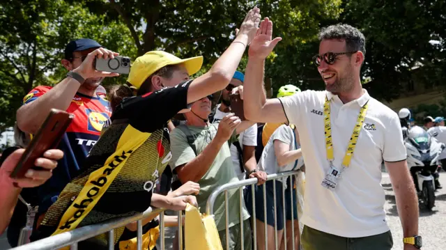 Mark Cavendish high-fives a cycling fan before stage 17 of the 2025 Tour de France