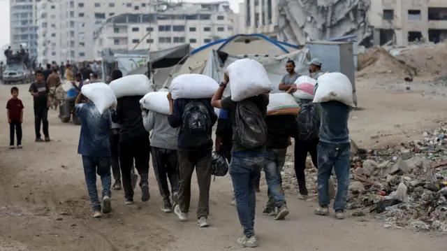 Palestinians carry aid