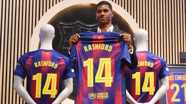 Marcus Rashford holding Barcelona shirt