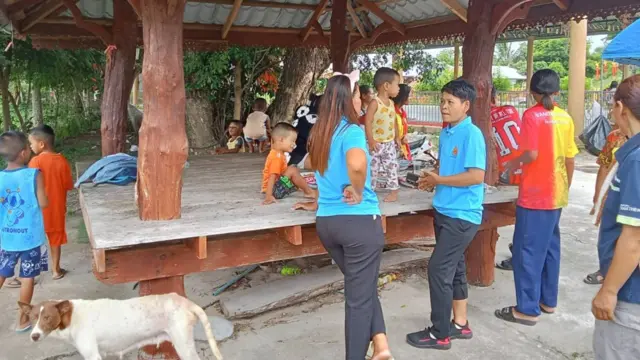 People gathering at a hut
