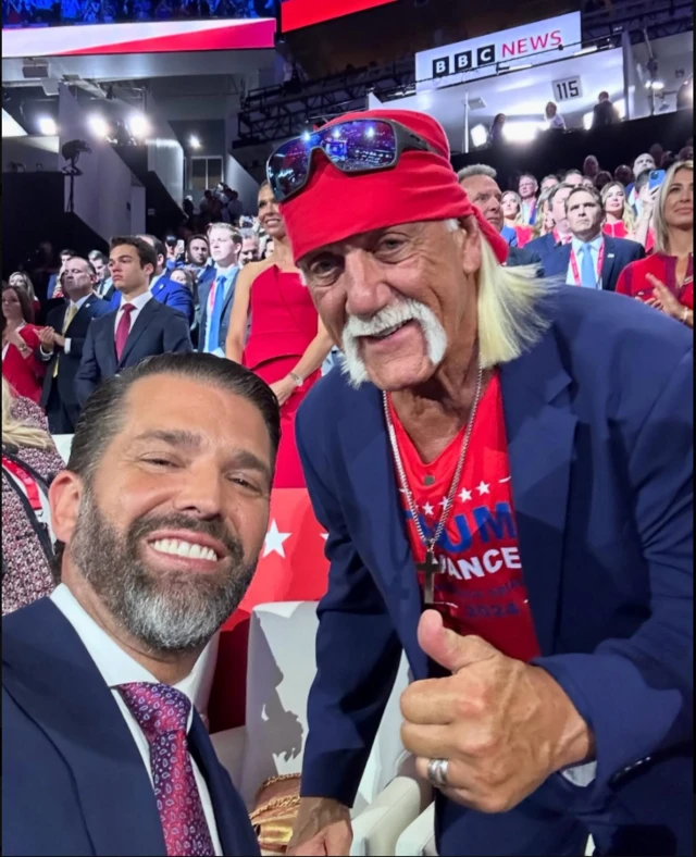 Trump Jr (left) and Hulk Hogan pose for a selfie. Hogan is wearing MAGA T-shirt and is giving a thumbs up.