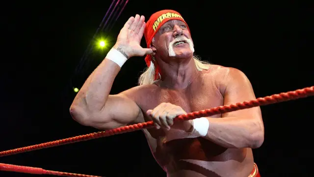 Hulk Hogan in the ring with a hand to his ear