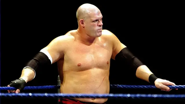 Kane in the ring in 2009, wearing no shirt and there are scratch marks on his stomach.