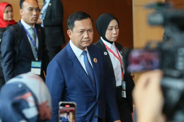 Hun Manet the Prime Minister of Cambodia walking in a suit alongside colleagues