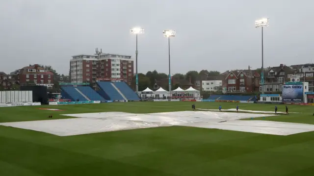 The covers are on at Hove as the rain comes down