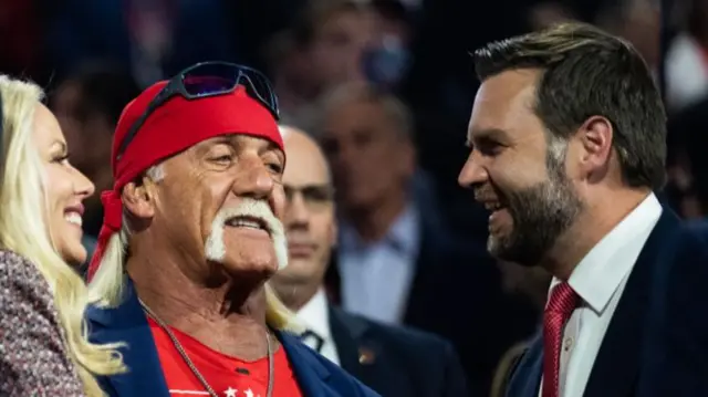 Hogan stood looking forward with Vance smiling next to him
