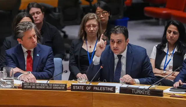 Deputy Palestinian Ambassador to the UN Majed Bamya shows pictures of people martyred by Israel during a UN Security Council meeting on the situation in the Middle East on July 16, 2025, in New York