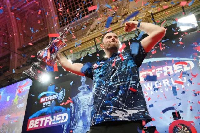 Luke Humphries celebrates with the trophy after winning 2024 World Matchplay