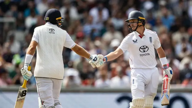 Joe Root and Ollie Pope shake hands at Old Trafford.