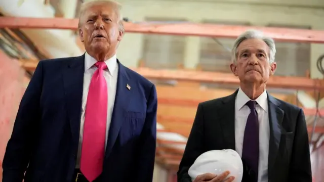 President Trump and Federal Reserve chair Jerome Powell on a tour of building work at the Federal Reserve. Powell is holding a white hard hat.