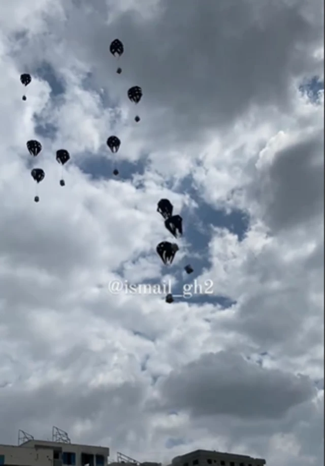 Footage of an aid drop show boxes plummeting to the ground