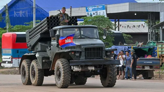A Cambodian soldier stands on a truck carrying a Russian-made BM-21 rocket launcher travelling along a street in Oddar Meanchey province on 25 July