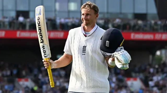 Joe Root smiles with his helmet and bat after leaving the pitch after getting 150 runs at Old Trafford.