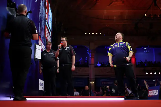 Luke Littler celebrates after beating Josh Rock