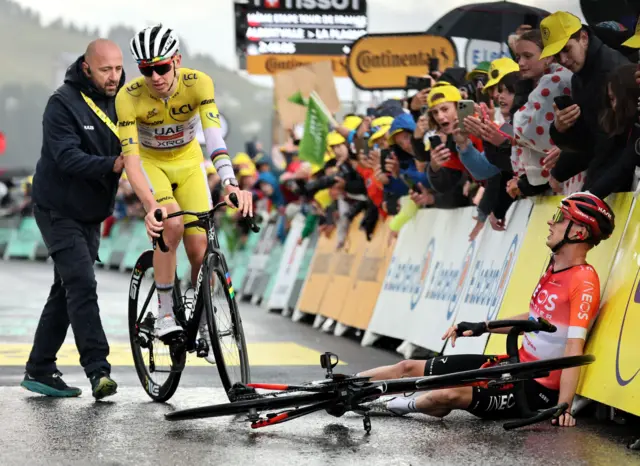 Thymen Arensman sits on the tarmac after winning stage 19 of the Tour de France