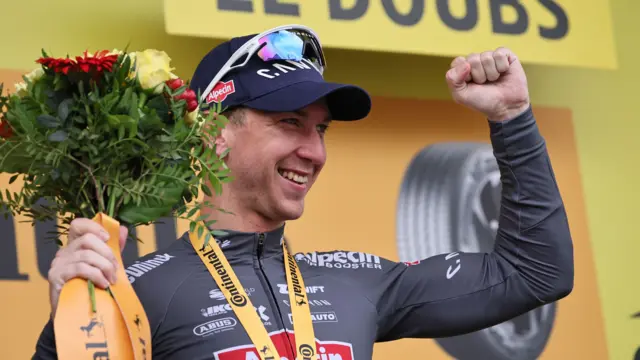 Kaden Groves celebrates on the podium after winning stage 20 of the Tour de France